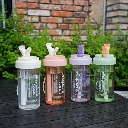 Havefy pastel fruit infuser straw bottles in white, pink, purple, and green on a black table outdoors.